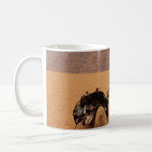TAZA DE CAFÉ DOS CAMELLOS SENTADOS EN ARENA MARRONA CERCA DE LA