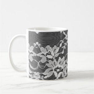 Taza De Café Encaje floral blanco sobre un fondo negro.