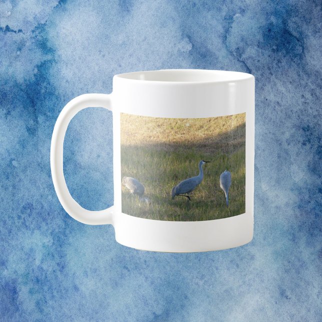 Taza De Café Foto de Aves de Sandhill Cranes (A mug with a photo of three sandhill crane birds grazing in the grass.)