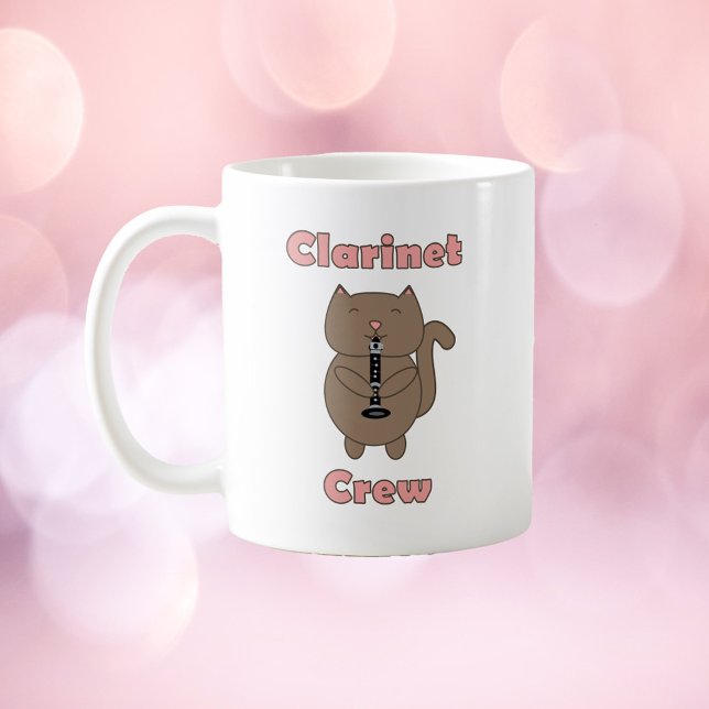 Taza De Café Gato marrón de la tripulación del Clarinet (A mug with a brown cat playing the clarinet and the words clarinet crew in pink.)