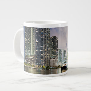 Taza De Café Gigante Torres iluminadas en la costa del río de Miami