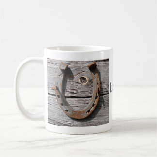 Taza De Café Herradura afortunada en la cerca de madera