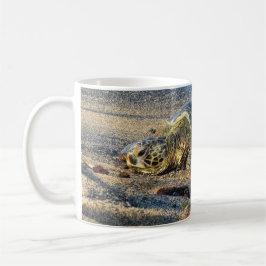 Taza De Café Honu que descansa sobre la arena