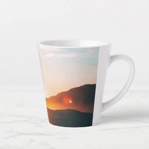 Taza De Café Latte amanecer sobre una montaña