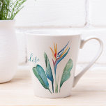 Taza De Café Latte Ave tropical de hojas de palmeras verdes paraísas<br><div class="desc">Traiga el calor del verano a su casa con estas insólitas tazas tropicales de latte, con un pájaro acuático vibrante del paraíso y exuberantes hojas de palma sobre un crujiente fondo blanco. El guión con letras a mano en azul turquesa dice "Bienvenidos a nuestro paraíso", añadiendo un ambiente de playa...</div>