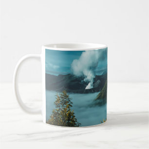 TAZA DE CAFÉ MONTAÑAS VERDES RODEADAS DE NUBES BLANCOS