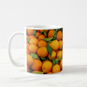 Taza De Café Muchos Naranjas coloridos con hojas verdes