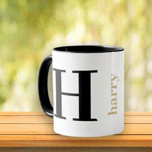 Taza de café negra dorada con monograma moderno y