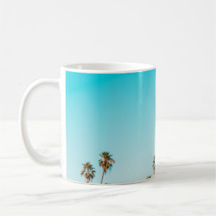 TAZA DE CAFÉ PALMERAS VERDES Y MARRÓN BAJO CIELO AZUL CLARO