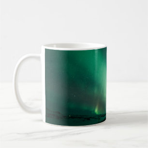 TAZA DE CAFÉ PERSONA PARADA FRENTE A LAS LUCES DE AURORA