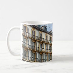 TAZA DE CAFÉ PERSONAS CAMINANDO CERCA DEL EDIFICIO BEIGE CONCRE