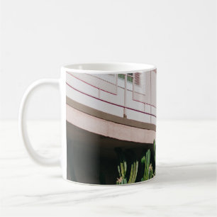 TAZA DE CAFÉ PLANTA VERDE DE COLOR ROSADO CERCA DEL EDIFICIO