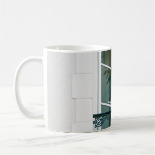 TAZA DE CAFÉ PLANTA VERDE EN LA VENTANA BLANCA