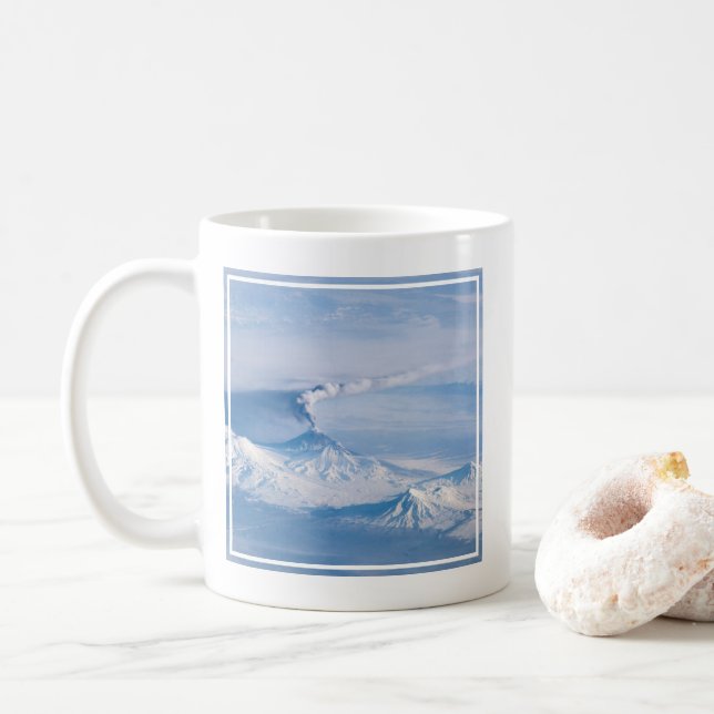 Taza De Café Pluma Emanando Del Volcán Kliuchevskoi. (Con donut)