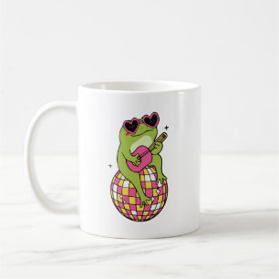 Taza De Café Rana sentada en pelota de baile tocando guitarra