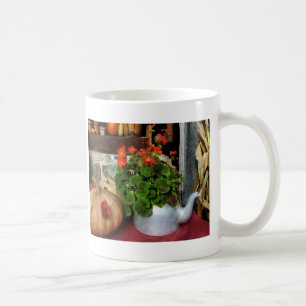 Taza De Café Tetera llenada de los geranios