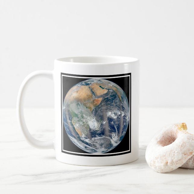 Taza De Café Tierra Llena Que Muestra El Hemisferio Oriental. (Con donut)