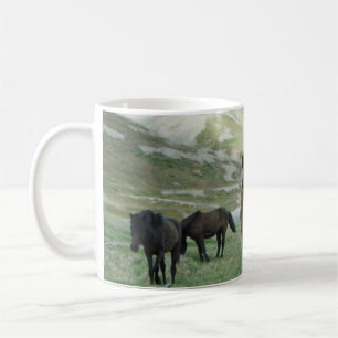 TAZA DE CAFÉ UN GRUPO DE CABALLOS EN UNA PASTURA DE MONTAÑA