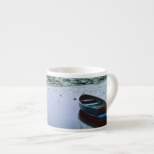 Taza De Espresso Bote de remos en un pequeño lago rodeado de agua