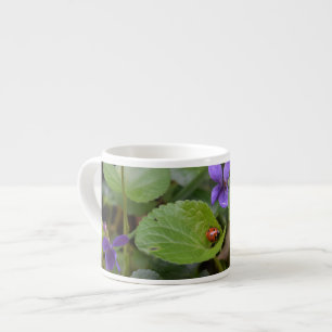 Taza De Espresso Ladybug sobre las dulces flores violetas