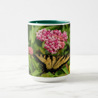 Taza de la mariposa con las flores del milkweed