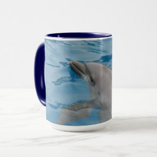 Taza Delfín deslizándose a través de agua azul clara