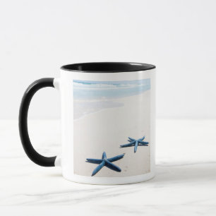 Taza Dos estrellas de mar azules en el borde del agua