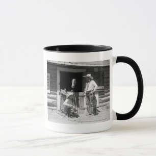 Taza Dos vaqueros que se colocan al lado de un granero