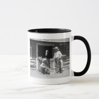 Taza Dos vaqueros que se colocan al lado de un granero