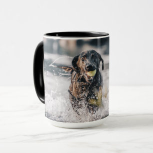 Taza El Labrador Negro Juega A La Obra En El Agua
