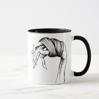 Taza encuadernada de las manos