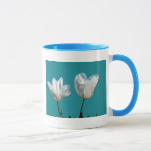 Taza flores de tulipán blancas con fondo azul acuático