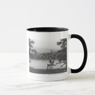 Taza Ganado por una charca con dos vaqueros