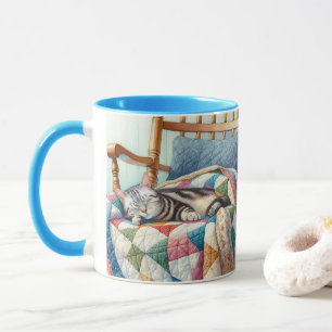 Taza Gato grisáceo dulce durmiendo en un montón