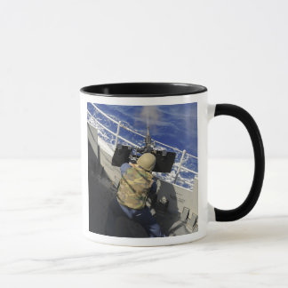 Taza Gunners Mate disparando una ametralladora calibre 