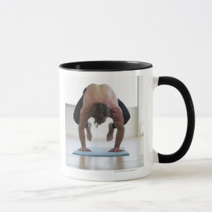 Taza Hombre que hace entrenamiento en la estera de la