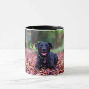 Taza Labrador negro en hojas de otoño