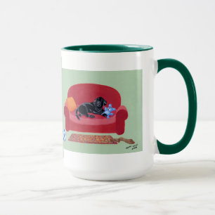 Taza Labrador negro en la pintura rosada del sofá