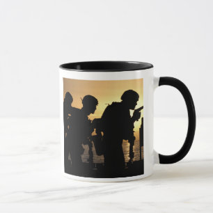 Taza Los infantes de marina encienden las armas de mano