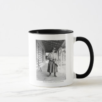 Taza Mujer que sostiene un rifle en un pórtico