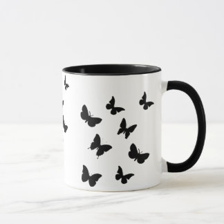 taza negra y blanca de las mariposas