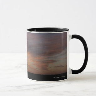 Taza Nubes en un cielo anaranjado en la salida del sol