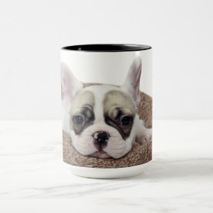 Taza Perrito del bulldog francés que miente en una cama