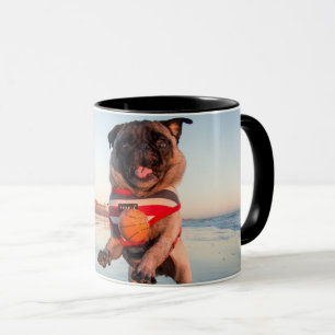 Taza Pug jugando a pelota en la playa
