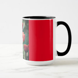 Taza roja del campanero con los tulipanes rojos