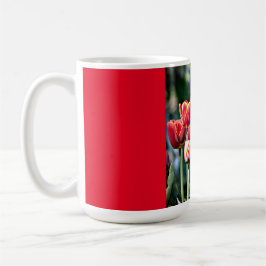 Taza roja del campanero con los tulipanes rojos