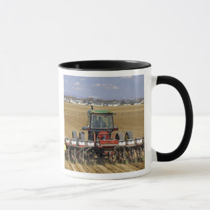 Taza Tractor que tira de un plantador del maíz de