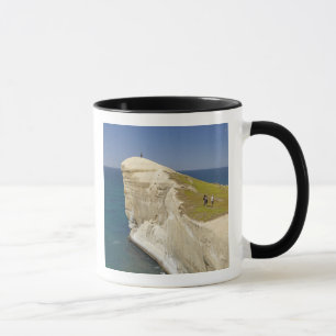 Taza Turistas en la cima del acantilado en Tunnel Beach