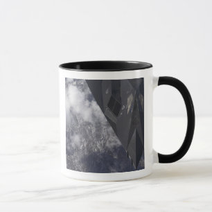 Taza Un F-117A Nighthawk vuela alto sobre la montaña