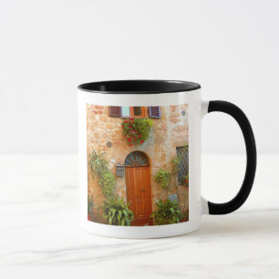 Taza Un gato busca entrada a casa en Pienza, Italia.